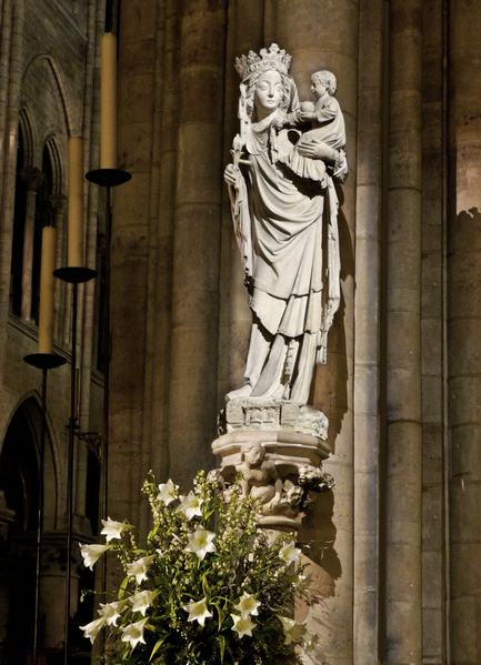 Virgin Mary and baby Jesus statue in Notre-Dame de Paris cast in Philips LED light
